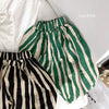 Green and cream striped cotton harem pants for kids laid out on a white surface.