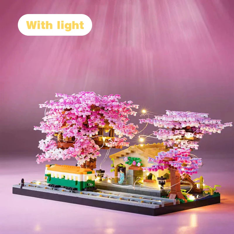 A miniature pink sakura tree building block set illuminated with lights on a dark base.