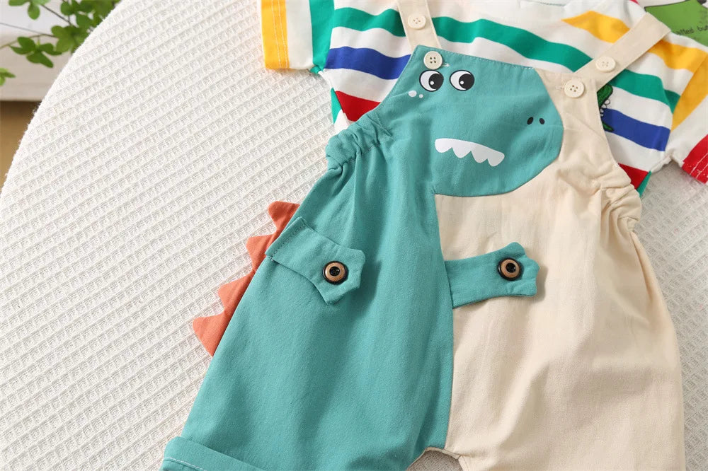 A light blue dinosaur romper and matching top with stripes, laid out on a white textured surface.