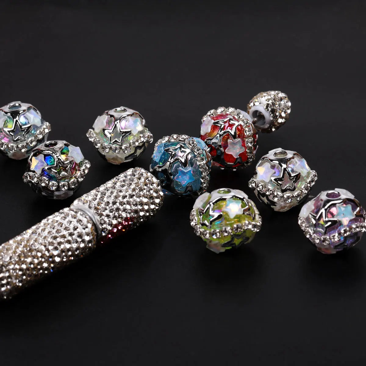 A collection of silver star rhinestone acrylic beads and a silver-studded tool for jewelry making