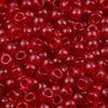 A close-up view of small, translucent red pony beads for jewelry making and craft projects.