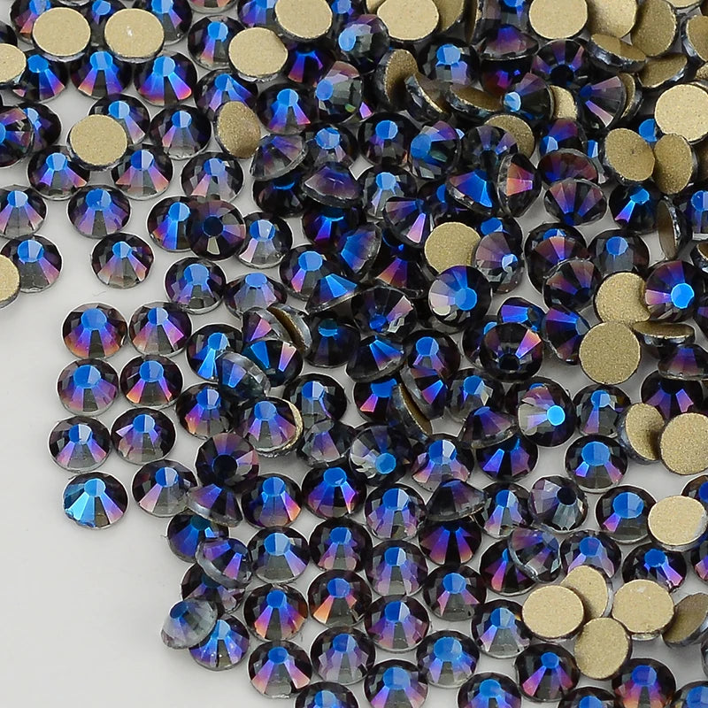 A close-up view of iridescent blue and purple glass crystal flatback rhinestones mixed with gold-toned rhinestones.