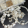 A collection of white and gold acrylic pearl beads, including hearts, flowers, and butterflies, for jewelry making.