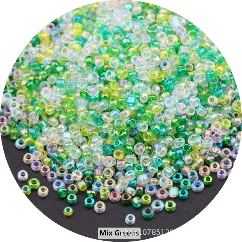 A pile of colorful round loose glass seed beads in various shades of green and clear for jewelry making