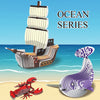 A set of 3D paper animal puzzles featuring a wooden boat, a sea turtle, and a red crab on a sandy background.