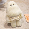 A white, fluffy monster plush doll with small eyes and a bow, resting on a light-colored surface.