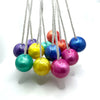 A collection of colorful, shiny fidget balls suspended on white strings.
