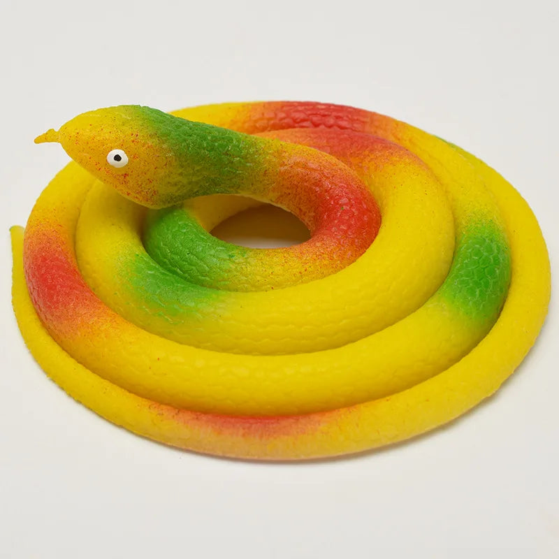 A realistic rubber snake toy with yellow, green, and red coloring coiled on a white background.
