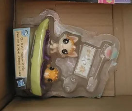 A clear plastic bag containing three small animal figures, including a light green cat and two other small toys.