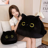 A woman is holding a large black cat plush toy and a smaller black cat plush toy on a light-colored sofa.