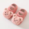 Pair of pink fuzzy cartoon bear baby booties with pink straps and light brown accents