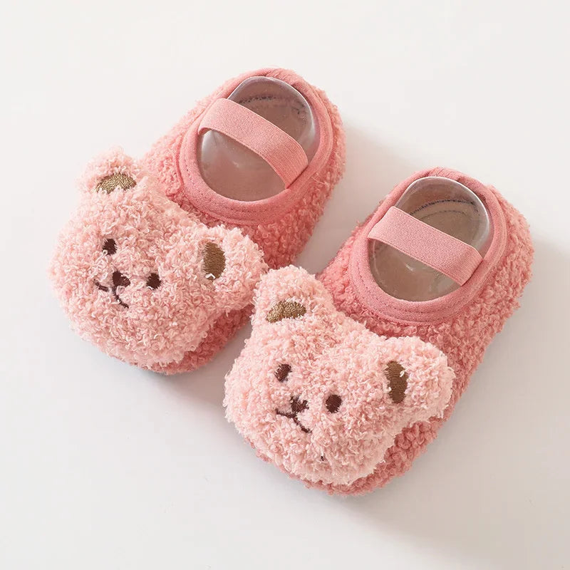 Pair of pink fuzzy cartoon bear baby booties with pink straps and light brown accents