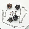 A set of metal polyhedral dice including a cube and a dodecahedron, displayed with accompanying chains and a pendant storage 