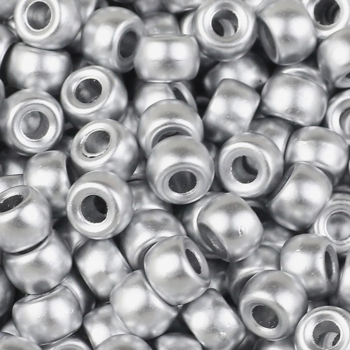 A close-up view of small, silver-colored pony beads for jewelry making and craft projects.