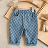 Light blue plaid corduroy pants for toddlers displayed on a wooden hanger.