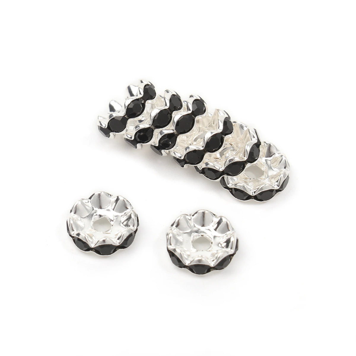 A collection of 12mm crystal rhinestone spacer beads in black and clear pave settings for jewelry making.