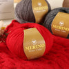 A bright red Merino wool yarn skein resting on a red knitted fabric with a brown label.