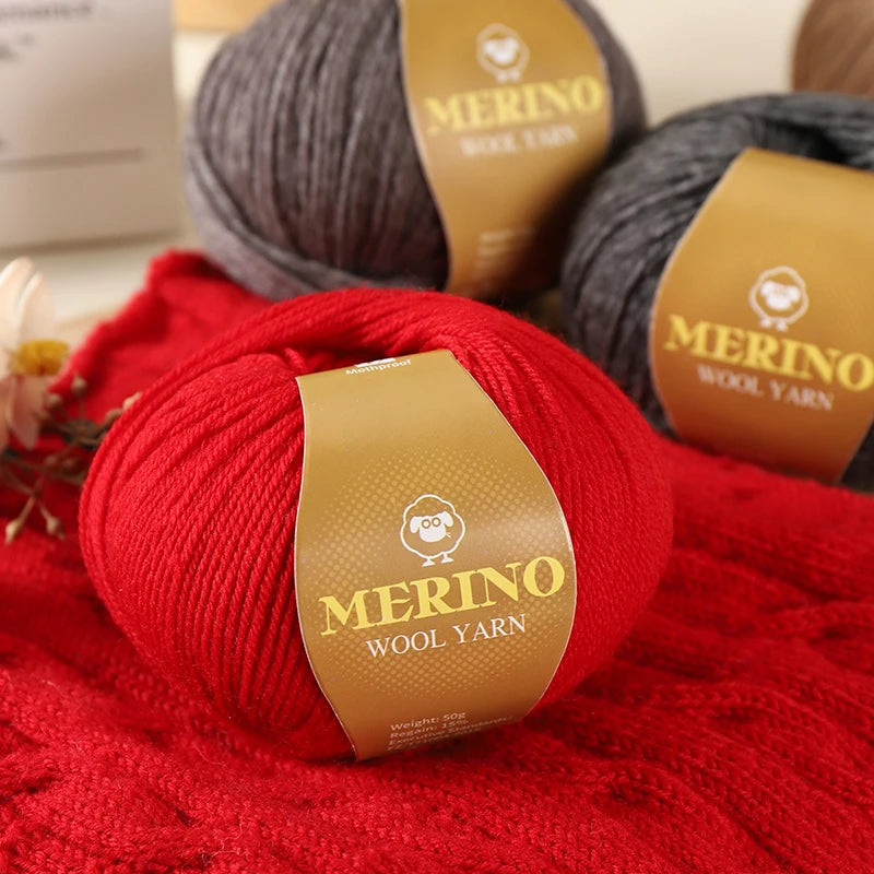 A bright red Merino wool yarn skein resting on a red knitted fabric with a brown label.