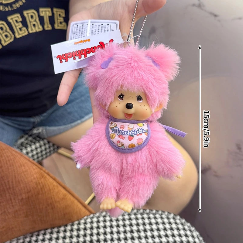 A pink fluffy cartoon plush toy with a stitched face and purple accents is being held by a person.