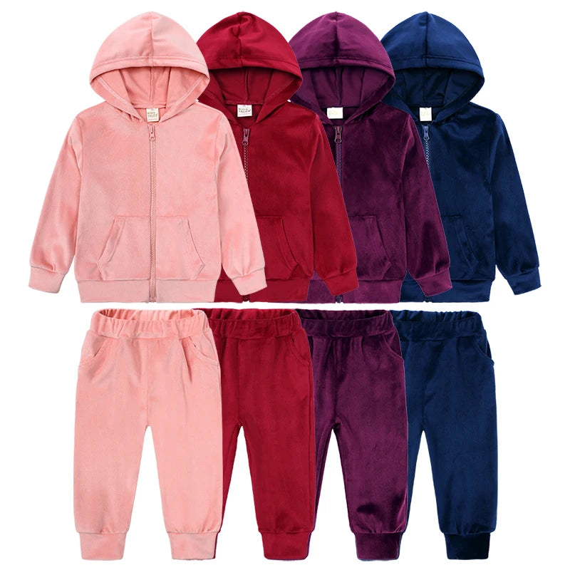 A set of kids' velvet tracksuit featuring a hooded zipper coat and matching pants in various shades of pink, red, purple, and