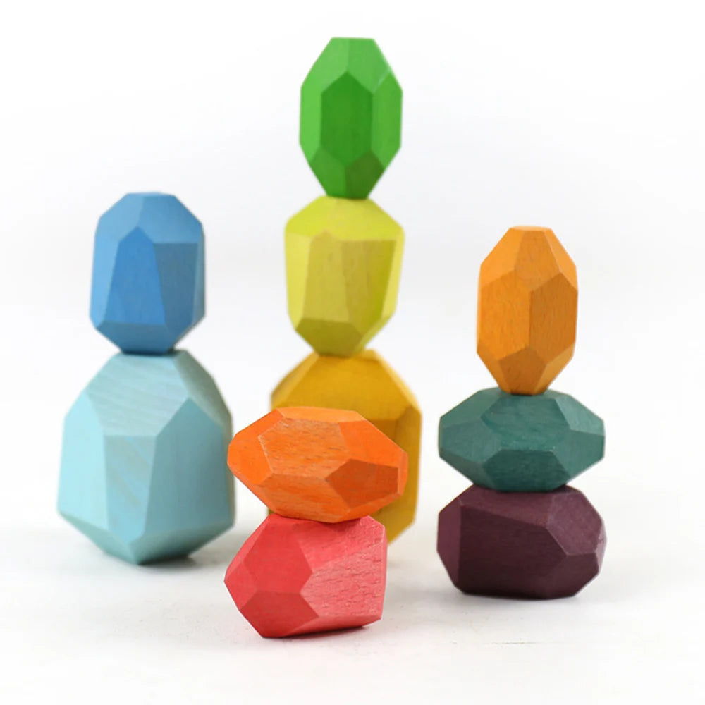 Une pile de cinq blocs sensoriels en bois de différentes couleurs : bleu, jaune, orange, vert et violet.
