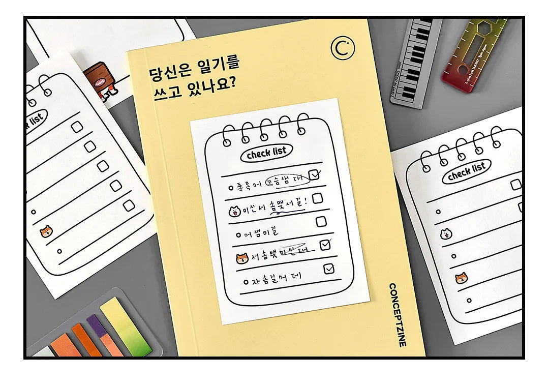 A yellow notebook with a checklist page is displayed next to various stationery items like pens and a pencil.
