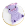 A cute purple elephant silicone baking mold with a pink bow, resting on a round wooden surface.