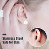 Close-up of a hand holding an ear with a small silver earring stud base.