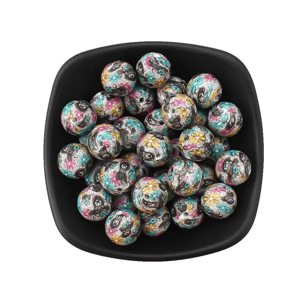 A black bowl filled with colorful printed silicone beads featuring leopard and daisy patterns.