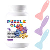 A white bottle of Puzzle Glue with a purple and orange label and a pink plastic spatula next to it.