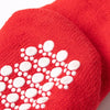 A close-up of a bright red knitted sock featuring white festive Christmas designs.