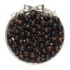 A pile of dark brown and black round resin beads for jewelry making, tied with a silver bow.