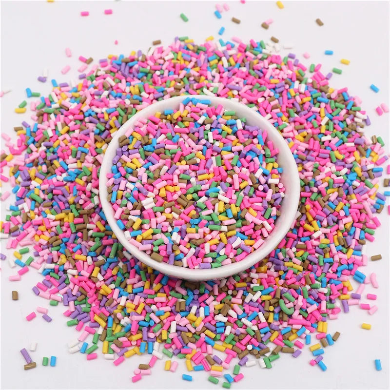 A bowl filled with colorful polymer clay slice sprinkles scattered on a white surface.