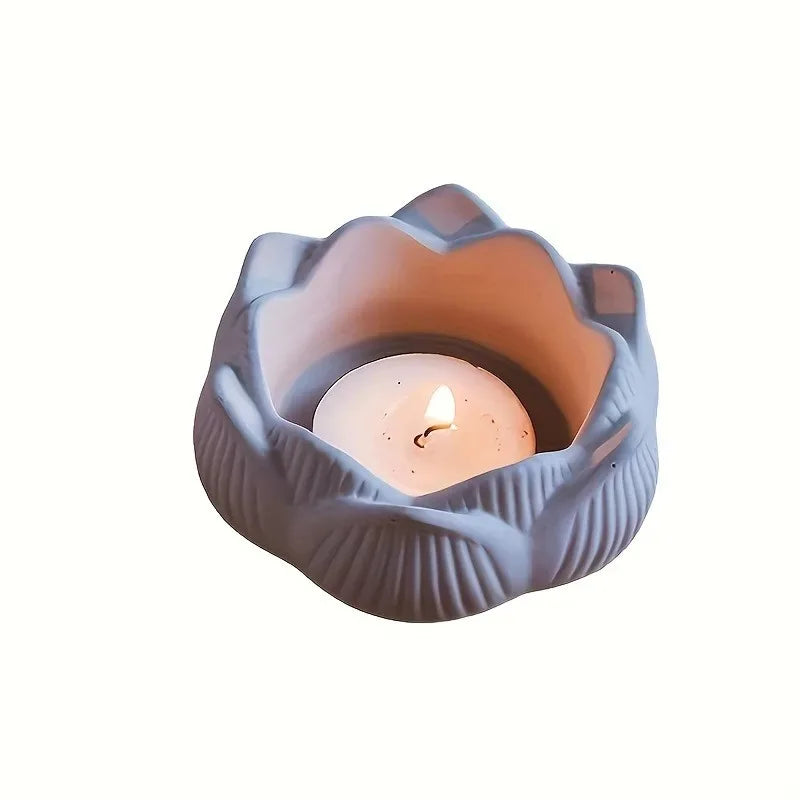 A light gray silicone mold shaped like a lotus flower holding a glowing candle.