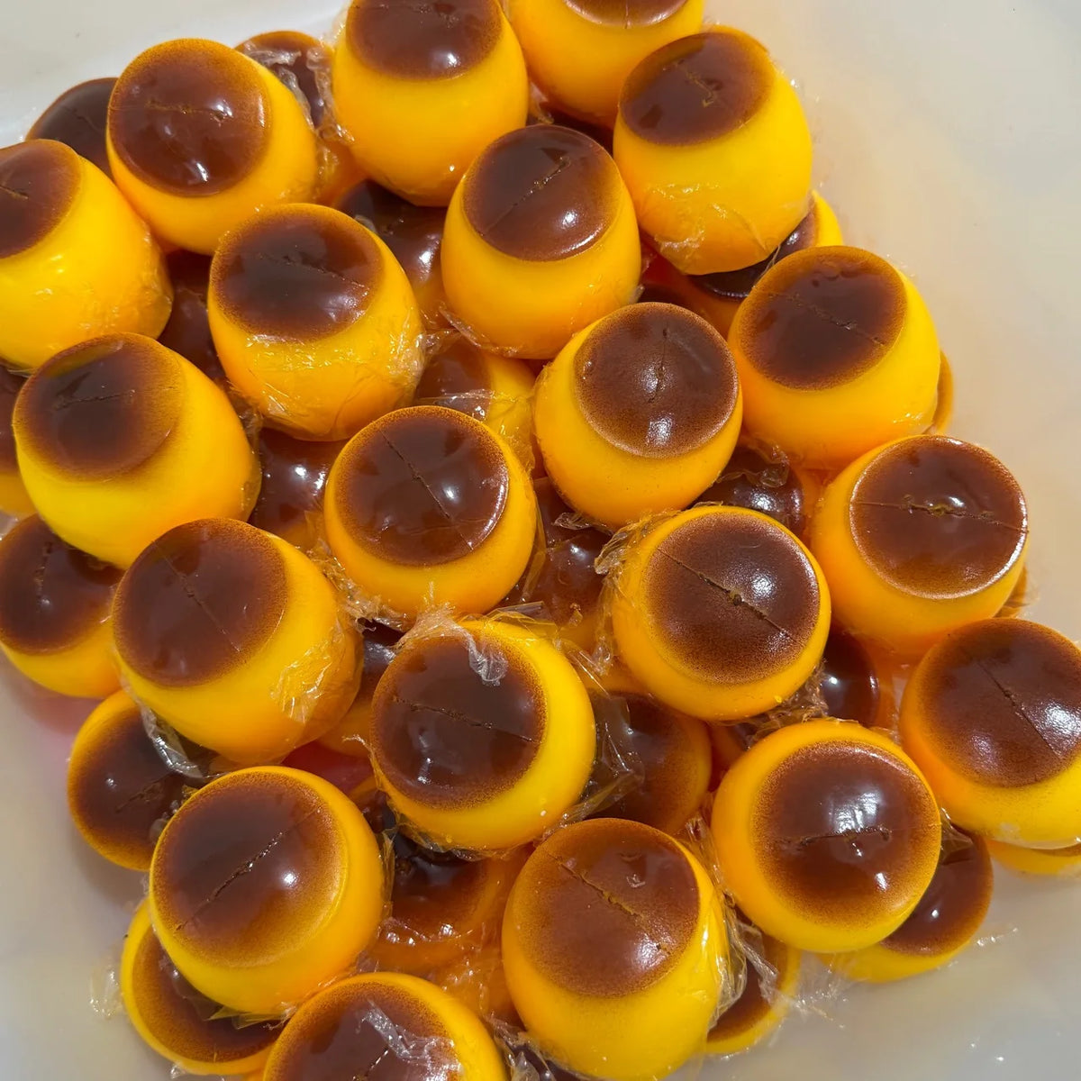 A pile of yellow and brown squishy pudding stress balls or fidget toys