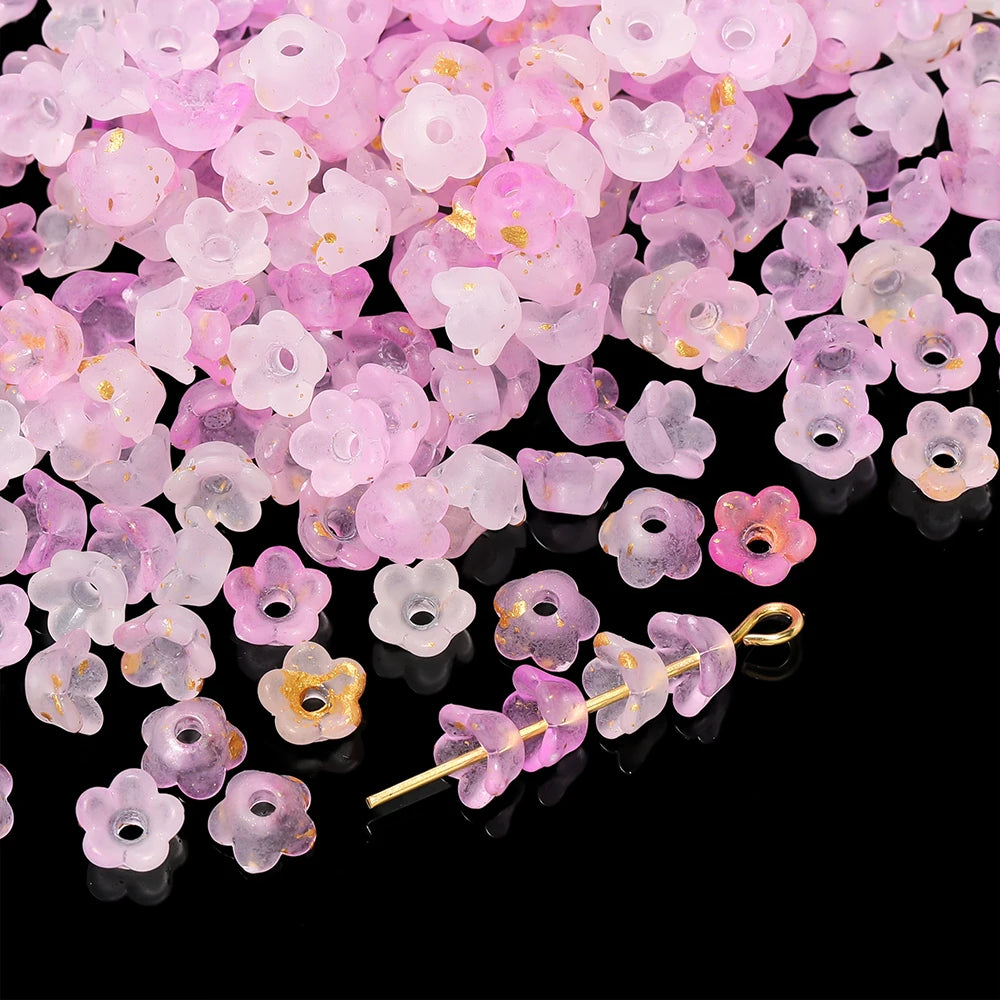A pile of pink and purple gradient acrylic bellflower beads for jewelry making