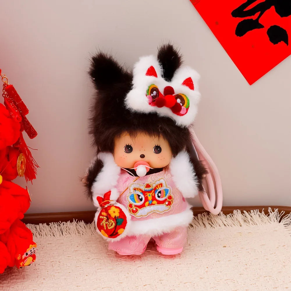 A cute Monchhichi plush keychain with black and white fur, pink clothing, and an elaborate headpiece.