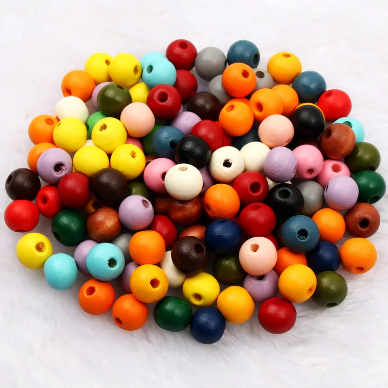 A pile of natural wooden beads in various colors including red, orange, yellow, green, and blue.