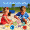 Two young children play with colorful stacking cups and floating boats in the sand.