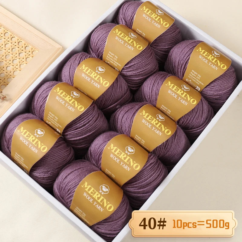 A box of purple Merino wool yarn balls with gold labels is shown for knitting projects.