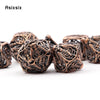 A set of coppery skull metal polyhedral dice used for tabletop role-playing games