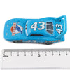 A blue diecast toy hauler truck with the number 43 on the side, shown next to a ruler.