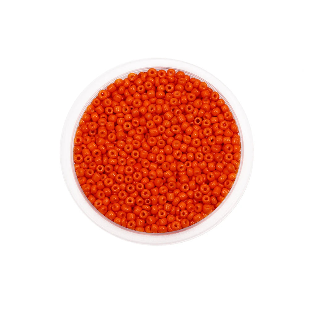 A clear container filled with bright orange Czech glass seed beads for jewelry making
