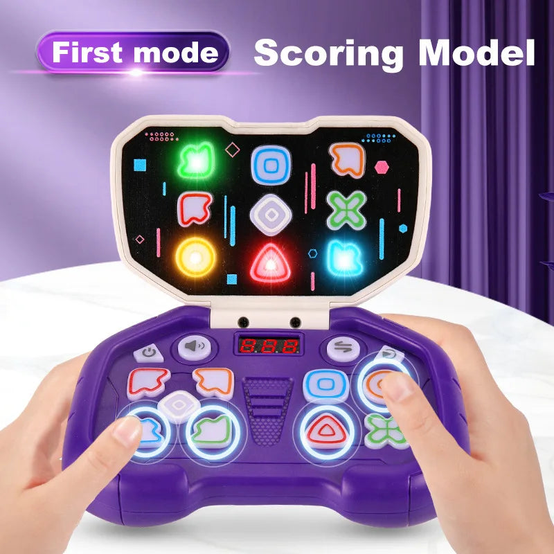 A hand holds a purple rhythm tap game console with a scoring model display showing various colored icons.