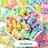 A bowl filled with pastel bear-shaped acrylic craft beads in various shades of pink, green, yellow, and blue.