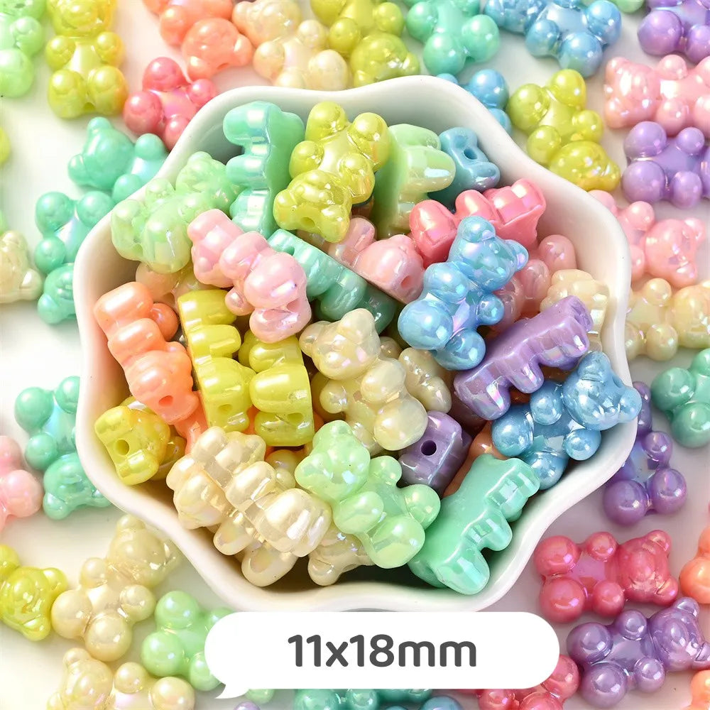 A bowl filled with pastel bear-shaped acrylic craft beads in various shades of pink, green, yellow, and blue.
