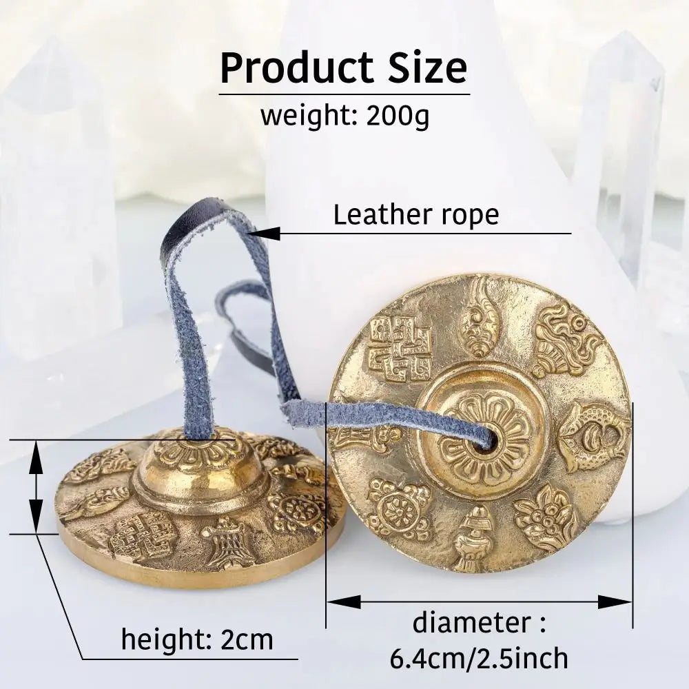 A round brass tingsha cymbal with eight auspicious symbols is shown next to a leather rope and product size measurements.