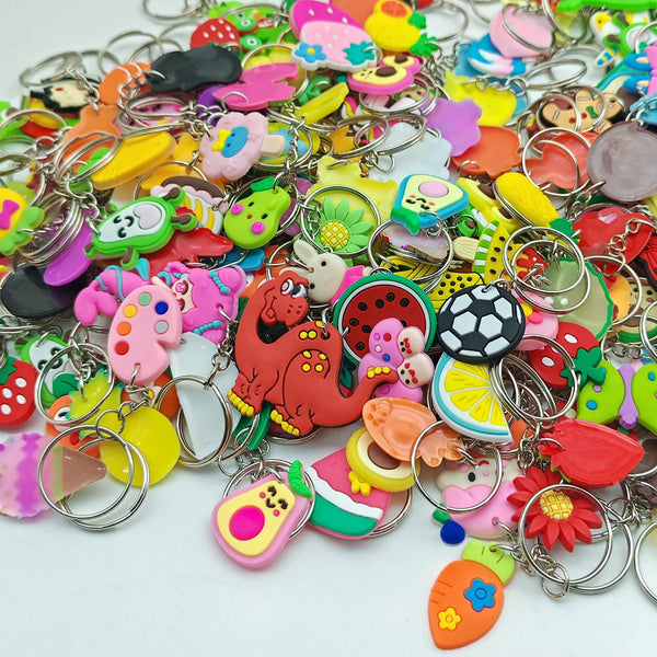 A large assortment of colorful cute cartoon character keychains and charms on a white background.
