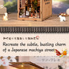 A wooden book nook kit depicting a miniature Japanese alley scene with detailed architecture and lighting.