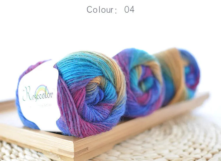 A bundle of hand-dyed rainbow merino wool yarn in various shades of blue, purple, and green.